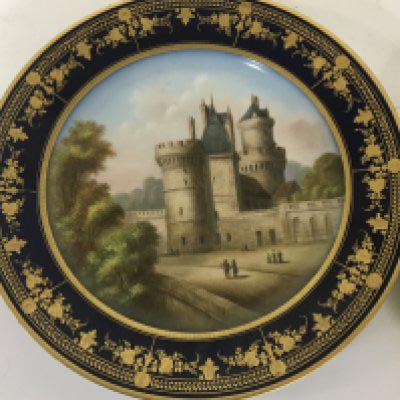 A Sevres porcelain hand painted cabinet plate a view of a chateau marks to the reverse some minor restoration and a hand painted porcelain plaque depicting a courting couple in 18th century dress in an oval gilt frame (2)