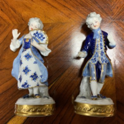 A pair of small porcelain 20th century figures. Postage cat D.