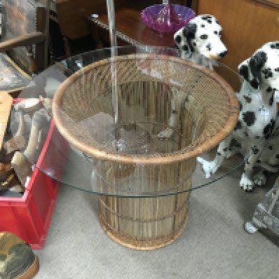 A wicker table with glass top dimensions 61.5cm tall and 76cm wide. NO RESERVE
