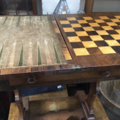 A Rosewood games table with twin flap top ; single drawer with fitted compartment on shaped supports