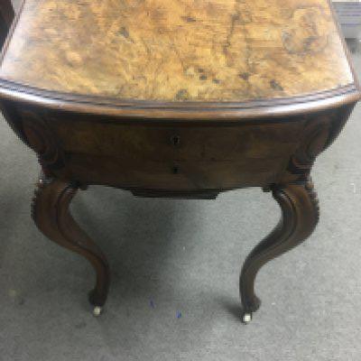 A Victorian walnut sewing table the twin flap top above cabirol Legs on casters .