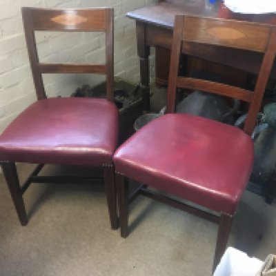 A set of eight Edwardian dining chairs including two carvers with red leather seats on square tapering legs .