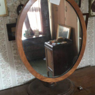A Victorian oval wall mirror on a turned support. Height 67cm