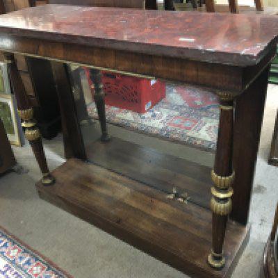 A Period Regency circa 1810 Console table with a red rectangular marble top above gilded rosewood pillars and inset with a rectangular mirror. Length 108cm height 92cm width 36cm.