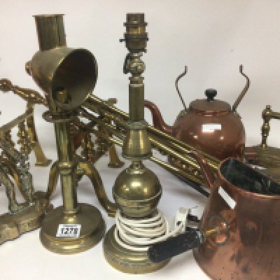 A collection of brass fire irons lamps a large brass trivia stand fire kerb and copper kettles.