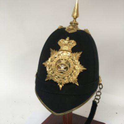 A Victorian Military helmet the interior with makers label with applied brass shako plate Royal Regiment of Wales possible re-badged.
