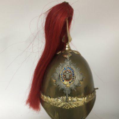 A Victorian brass Military helmet with Royal Welsh Regiment of Wales shako plate possible colour enhanced. With a red plume and missing chin strap and side chin strap fittings.