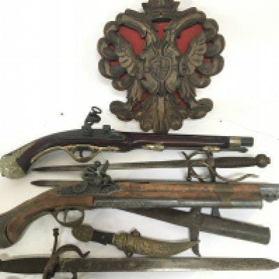 A collection of replica flintlock pistols and short swords.