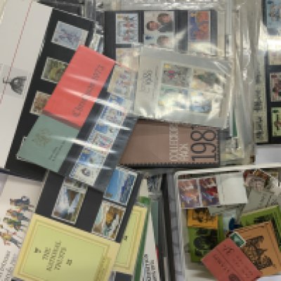 A large collection of stamp presentation packs, books and loose unused stamps.