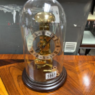 A 20th century brass clock under a glass dome. Postage category D.