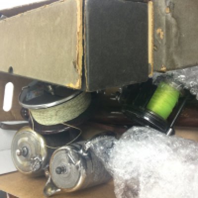 A box containing fishing reels, police truncheons, 2 pianolar rolls and silver plated set