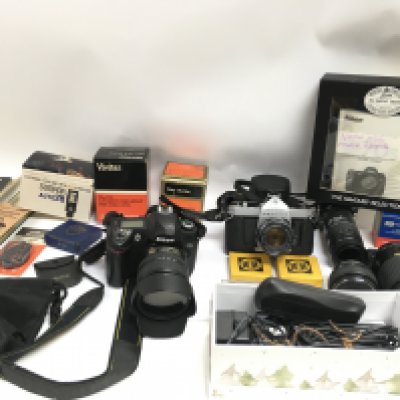 A Nikon camera along with additional camera equipment. Postage D
