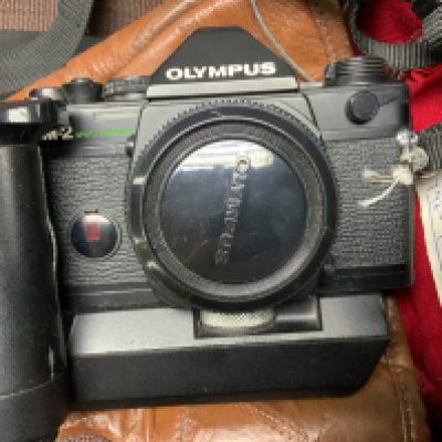 A Olympus OM2 body with lenses and accessories (D)