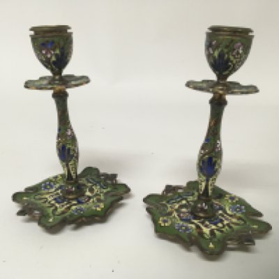 A pair of early 20th century enamel candle sticks with shaped bases. decorated with flowers and foliage. Hight 15cm