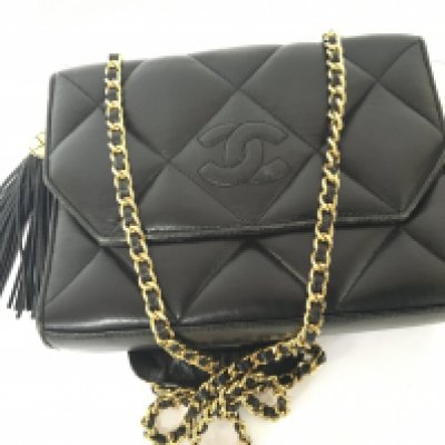 A 1960s Chanel ladies bag black quilted leather and with embossed Chanel interlaced C with applied gold finish strap black tassel the press stud with U.K. Pat 1519246 minor scuffs to the edges. 23x17cm