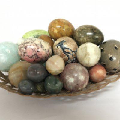 A collection of polished coloured stone eggs.