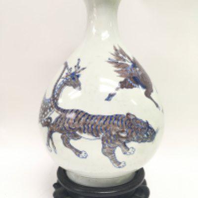 A Chinese pear shaped porcelain blue and copper red vase decorated with Qilin, Temple Dog etc, 27.5cm tall approximately. Six character mark at the base. No obvious large damage or restoration. This lot cannot be posted