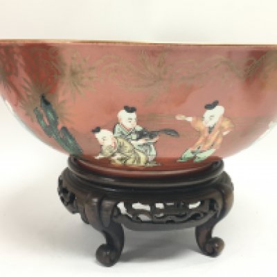A Chinese red coral ground famille verte and gilt decorated bowl. 25cm wide. This lot cannot be posted