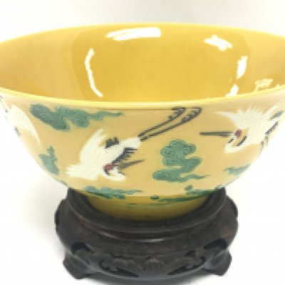 A Chinese yellow glaze bowl with decoration of cranes. 15cm wide. This lot cannot be posted