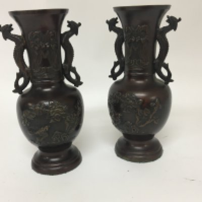 A pair of Japanese late 19th century vases with raised decoration and side handles in the form of dragons. Height 20cm.