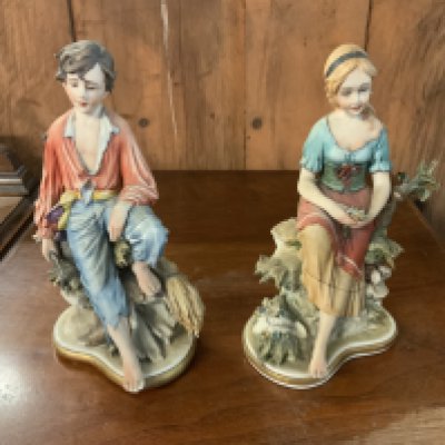 2 Capodimante porcelain figures of a seated young boy and girl. (D)