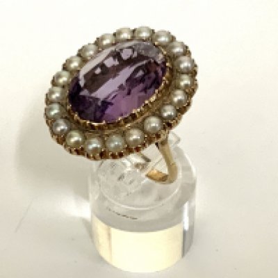 A 9ct gold dress ring inset with a large amethyst surrounded by seed pearls. (A)