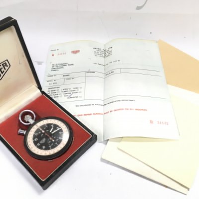 A cased vintage Heuer trackmaster stop watch with papers, seen working. Postage category A