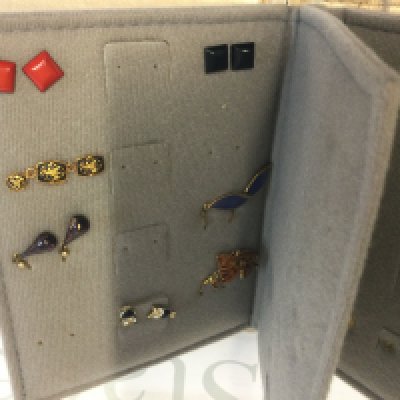A folder containing various earrings.