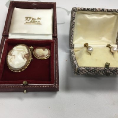 Two cameo brooches and a pair of pearl earrings.