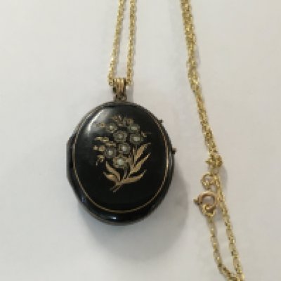 A Victorian locket inset with seed pearls with attached 9 ct gold chain.