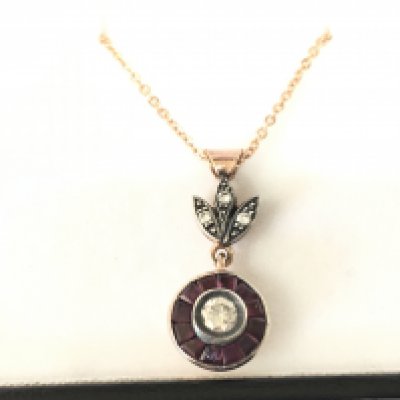 8ct rose gold target style pendant with floral bale set with RBC diamonds and calibre cut rubies on rose gold plated silver chain. Diamonds 0.30ct and Rubies 0.28ct approx.