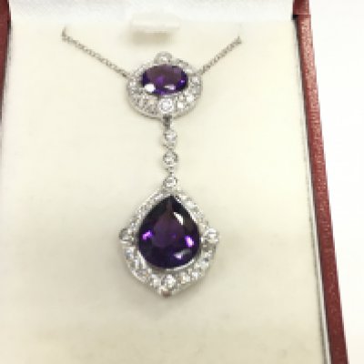 18ct white gold pendant set with a pear shaped amethyst an oval amethyst and RBC diamonds. Amethyst 4.23ct and diamonds 0.66ct. Postage B
