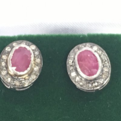A pair of oval ruby and RC diamond halo studs set in gold plated silver. Approximately 0.45ct rubies and 0.28ct diamonds.