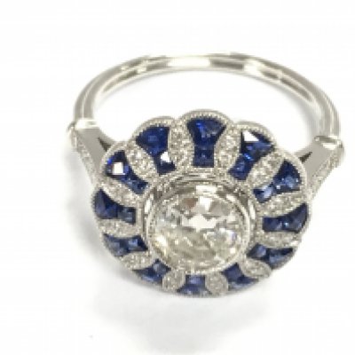 A stylish platinum target ring set with a central RBC diamond surrounded by mixed cut sapphires and RC diamonds. Centre diamond 0.79ct and sapphires 0.85ct remaining diamonds approximately 0.10ct. Size N 1/2