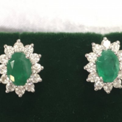A pair of 18ct white gold oval emerald and RBC halo studs. Emeralds 1.24ct and diamonds 0.80ct. Postage B