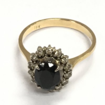 An 18ct gold ring set with a deep green Tourmaline approximately 1.3ct flanked by 14 diamonds. Size O 1/2 and 3.68g