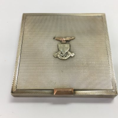 A silver hallmarked compact with a military insignia on the front.
