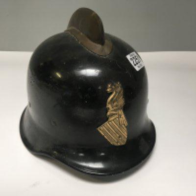 A Vintage French Firemens helmet with applied regional gilt metal badge and original lining.
