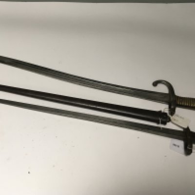 Two French bayonets an 1835 pattern with brass grip and an 1876 pattern with steel scabbard and wood and brass grip both with hook quilon. (2)