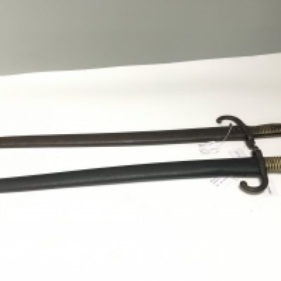 Two French bayonets the blade edge with inscriptions and dates both considered to be 1866 model bayonets with brass grips and steel scabbards (2)