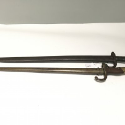 Two French bayonets an 1866 pattern with metal grip hook quilon and a later 1874 pattern with wood and brass grip both with metal scabbards. (2)