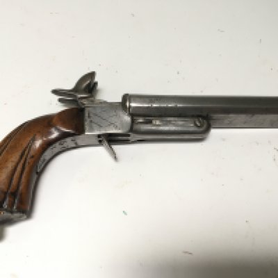 An Antique Continental early 19th century rim fire double barrel protection pistol with a carved walnut grip steel barrel and action retracting triggers action full functional.