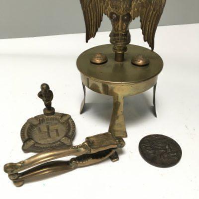 A I world war trench art brass shell top dated 1916 surmounted with an eagle and buttons a Lusitania medallion and Third Reich ash tray and nut cracks. (4)