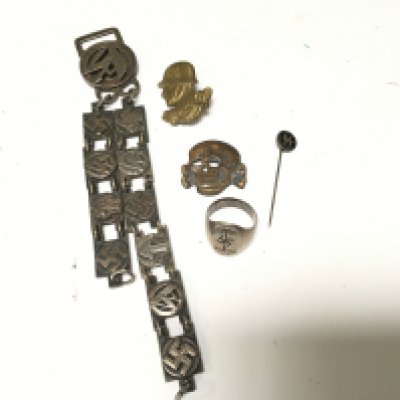 A German Third Reich Afrika Korps silver ring badges a stick pin and a presentation dagger hanger.
