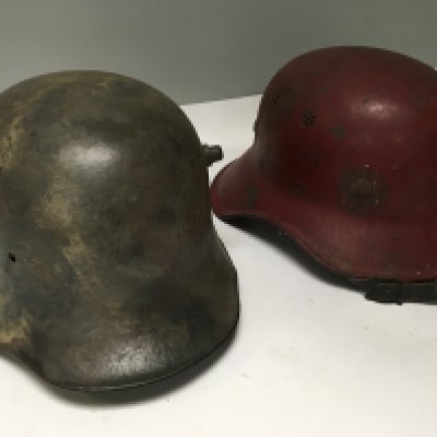 A Genuine I world war German Imperial Army steel combat helmet M-16 with painted internal name and number and a Post Second World War German red firefighter helmet (2)