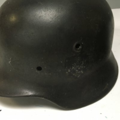 A Genuine German Third Reich M42 steel combat helmet possible SS the side with a faded decal no liner and one other Luftshutz Mk 1 helmet with liner folded edge stamp mark 20490 and painted owner soldiers name. (2)