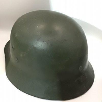 A German Third Reich steel helmet appearing to be original green paint no decal the back edge with an Applied original fitting and with liner no inner edge stamp marks.