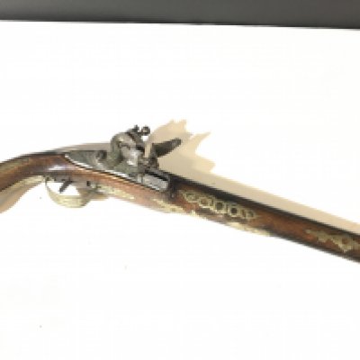 A Spanish late 18th century flintlock pistol with a brass inlaid walnut stock the barrel and action with further ornamentation action functions