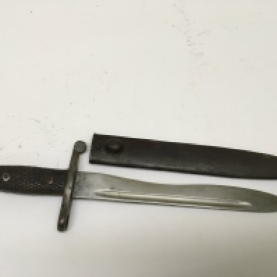 A German Bayonet possible an 1894/89 pattern with wood grip steel cross guard and shaped edge blade metal scabbard.