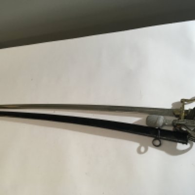 A German Third Reich Military officers dress sword with a brass grip with Swastika and attached pommel the blade with ornate double sided and edge pattern Fullered with slightly curved blade. Good condition.